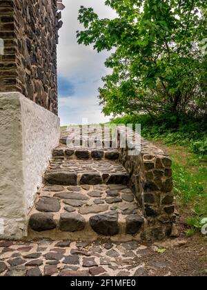 Stone stairs with a small stone wall at the side of the building Stock Photo