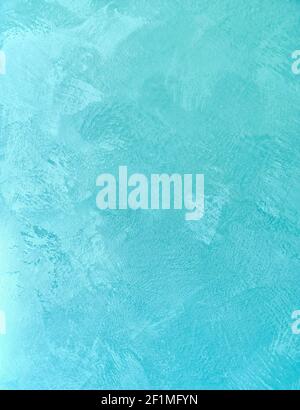 Background bright azure color made by decorative texture stucco. Wall designing finish plaster which imitation of stone. Stock Photo