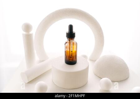 Blank amber glass face serum bottle on white background. Natural cosmetics, alternative medicine, minimal concept. Abstract background with different Stock Photo