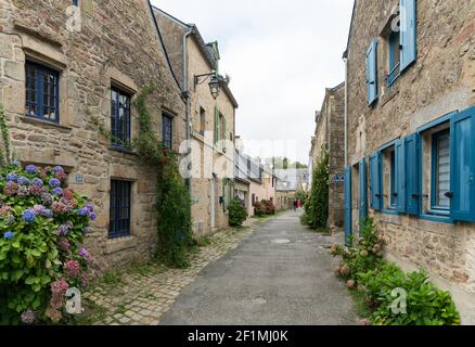 Older couple walks through the narrow streets of an idyllic French village Stock Photo