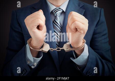 Businessman arrested for corruption. Man in a suit with handcuffs on his hands Stock Photo