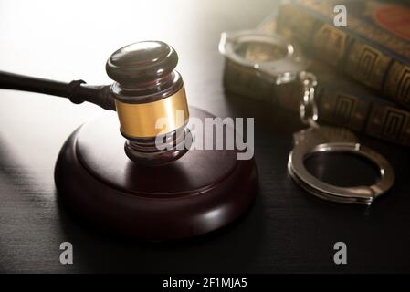 Judge gavel in court. Legal and justice concept. Library, books and handcuffs Stock Photo