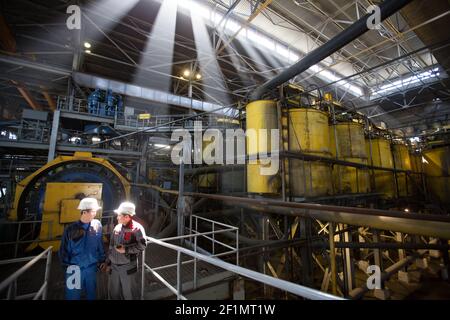 Khromtau/Kazakhstan - May 06 2012: Copper ore concentration plant workshop. Outokumpu Technology equipment. Two Asian engineers discussing on industri Stock Photo