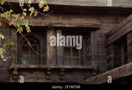 Old abandoned wooden house with wooden windows and shutters. Stock Photo