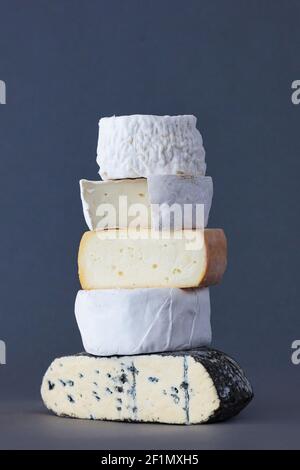 Stack Of Artisan Organic Cheese Against Grey Background Stock Photo