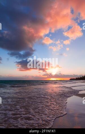 Colorful clouds in sunrise sky over Atlantic Ocean coast, Bavaro beach, Punta Cana. Dominican Republic. Vertical photo background Stock Photo