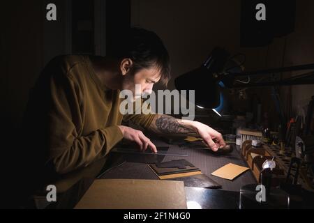 Person tailor who works with leather in workplace. Stock Photo