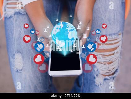 Network of social media icons and globe over woman using smartphone Stock Photo