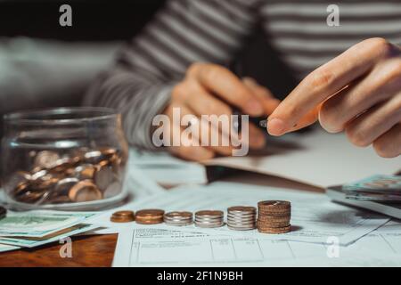 Young focused man paying bills online on computer laptop paper document on table worried about high bill invoice, overdue debt, expenses, expenditures Stock Photo