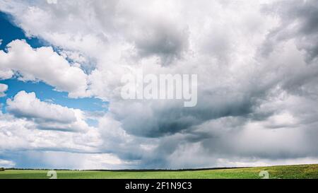 Countryside Rural Wheat Field Meadow Landscape In Summer Rainy Day. Scenic Sky With Rain Clouds On Horizon. Stock Photo