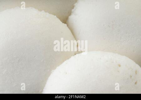 Idly or Idli, south indian main breakfast item which is beautifully arranged in a fresh green banana leaf on white background. Stock Photo