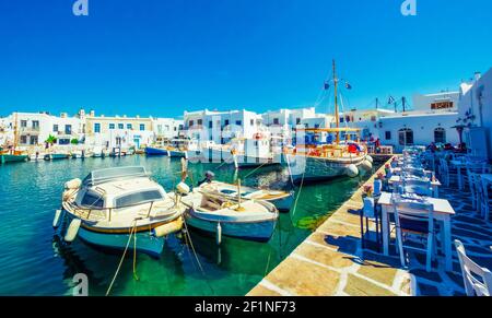 Parked boats in the harbor, near cafe at Paros, Greece Stock Photo