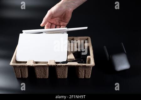 Man's hand unpacking wifi router on black background with wifi amplifier close to. Stock Photo