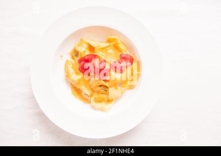 delicious stuffed mezzaluna pasta made from scratch with heirloom tomato sauce Stock Photo