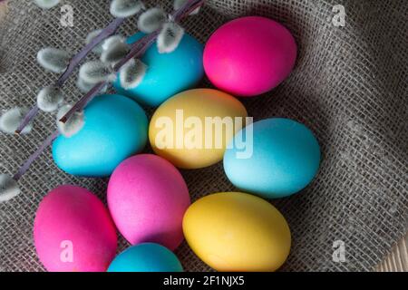 Painted Easter eggs lie on a natural matting along with willow branches. Stock Photo