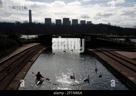 Sawley, Nottinghamshire, UK. 9th March 2021. A kayaker paddles in the shadows of Ratcliffe-on-Soar Power Station as Rushcliffe Borough Council is to discuss an expression of interest for UniperÕs coal-powered Power Station site to accommodate a nuclear fusion reactor when it is decommissioned in 2025. Credit Darren Staples/Alamy Live News. Stock Photo