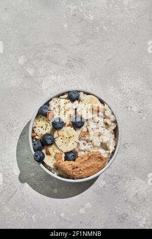 Breakfast: oatmeal with bananas, blueberries, chia seeds and almond butter Stock Photo