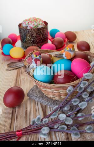 On the wooden table are two plates of Easter cake and painted eggs . Stock Photo