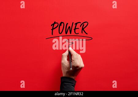 Male hand writing the word power on red background. Attaining power in business or life concept. Stock Photo