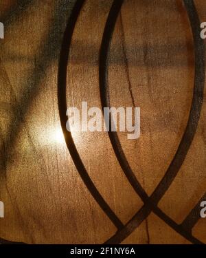 sunlight through old curtain and wrought iron curve on window frame Stock Photo