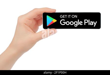 Kiev, Ukraine - February 17, 2021: Hand hold Download the Get it on Google Play black button, on white backround Stock Photo