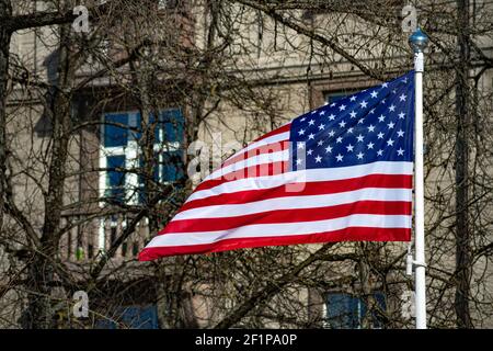 USA, United States, American flag waving in the city with buildings and park on background Stock Photo