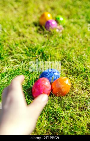 Easter eggs hidden in the grass, Colorful handmade painted Easter eggs hunt, Happy Easter Holiday concept in garden or park, Stock Photo