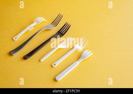 Range of forks. Various sort of forks on a yellow background. Stock Photo