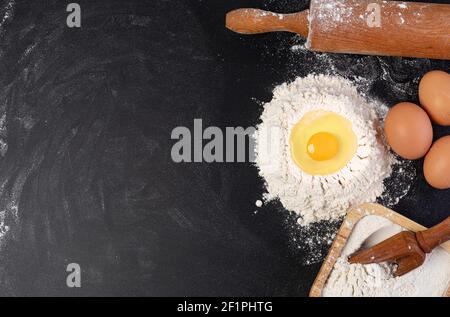Rolling pin and white flour on a dark background Stock Photo