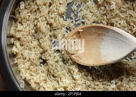 Rice frying and oiling in ghee  on steel pan closeup, process of cooking asian indian basmati ghee rice dish with Stock Photo