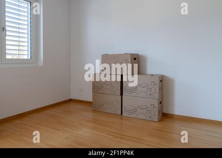 Large brown moving and packing boxes in an empty room Stock Photo
