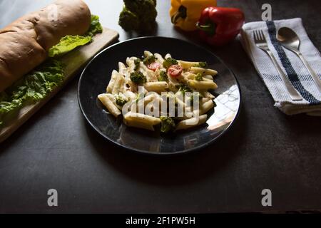 Close up of Popular Italian dish cheese penne pasta and bread Stock Photo