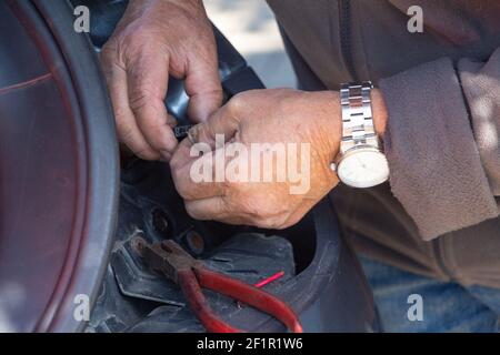 Mechanic repairing a car backlight in a backyard Stock Photo
