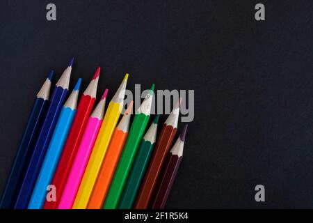 Colored pencils on a black background with copy space for text. Stock Photo