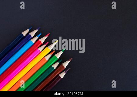 Colored pencils on a black background with copy space for text. Stock Photo