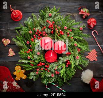 Christmas wreath and candles on wooden background Stock Photo