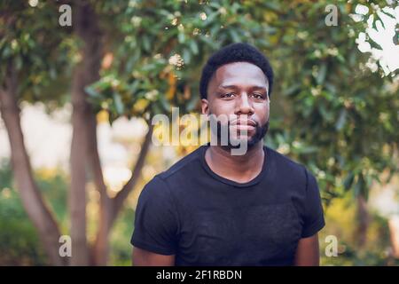 Headshot of a young black man wearing a black shirt - serious. Stock Photo