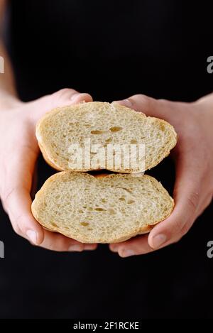 men's hands hold sliced bread on a dark background Stock Photo