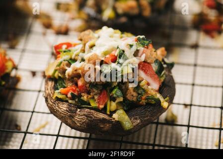 Freshly baked sausage stuffed mushroom on a wire rack Stock Photo