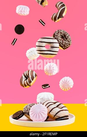 Flying donuts and marshmallows on a pink background Stock Photo