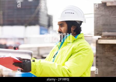 Worker young man with helmet and beard working outside Stock Photo