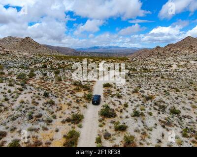 Aerial view of 4x4 car driving off road in the desert. Joshua Tree Stock Photo