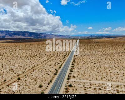 Aerial view of endless desert straight dusty asphalt road in Joshua Tree Park. USA. Stock Photo