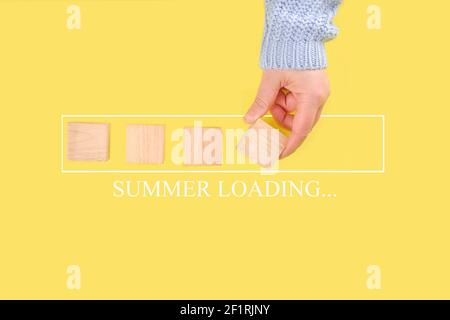 Loading summer concept with hand putting wood cube in progress bar on trendy bright yellow background flatlay Stock Photo