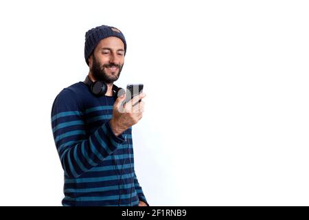 Man with headphones looking his cell smartphone. White background. Stock Photo