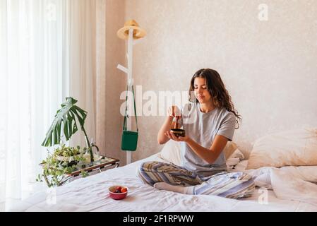 Stock photo of happy girl in pajamas relaxing and meditating in the bed. Stock Photo