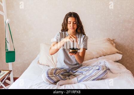 Stock photo of happy girl in pajamas relaxing and meditating in the bed. Stock Photo