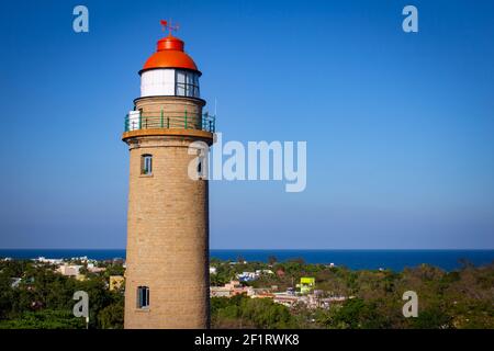 View of lighthouse from near by rock in Mahabalipuram, Tamil Nadu, India. Mahabalipuram is a town near Chennai famous for rock monuments and is a worl Stock Photo