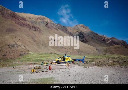 Rescue helicopter on a helipad in Andes Mountains with clear blue sky. Aconcagua National Park, Mendoza province, Argentina Stock Photo