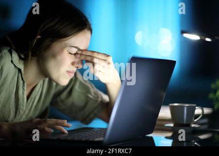 Fatigued woman suffering eyestrain using laptop complaining at night at home Stock Photo
